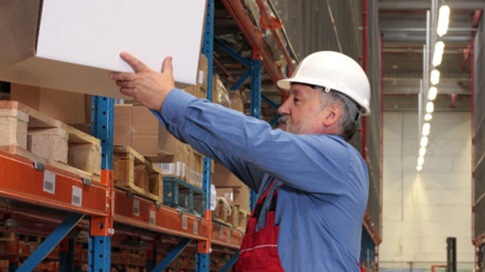 En lagerarbejder løfter en tung kasse
