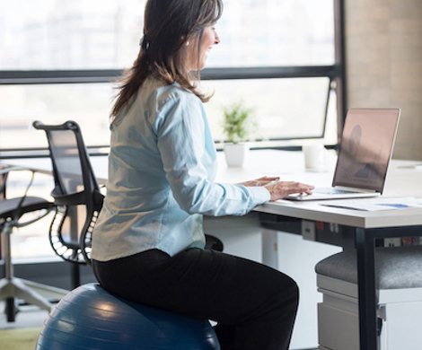 A femaler worker sitting on an exercise ball