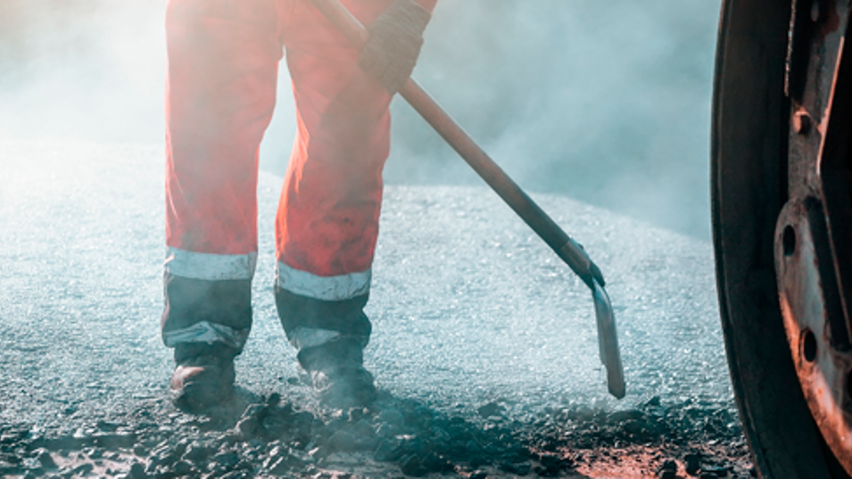 En vejarbejder der arbejder med asfalt