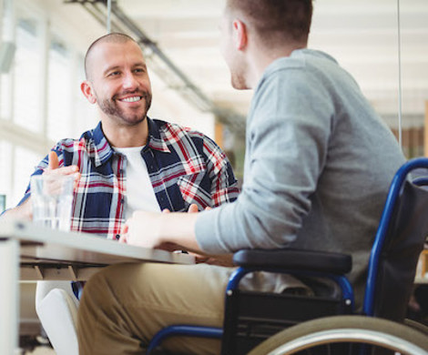  An employee in a wheelchair talking to a colleague.