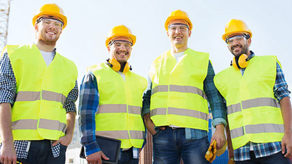 Fire byggearbejdere der står sammen på en arbejdsplads