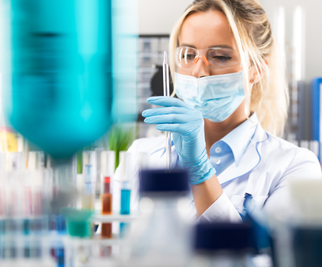 A laboratory technician with a lot of test tubes in front of her