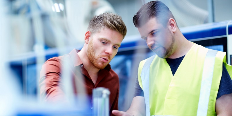 To personer snakker om en arbejdsopgave.