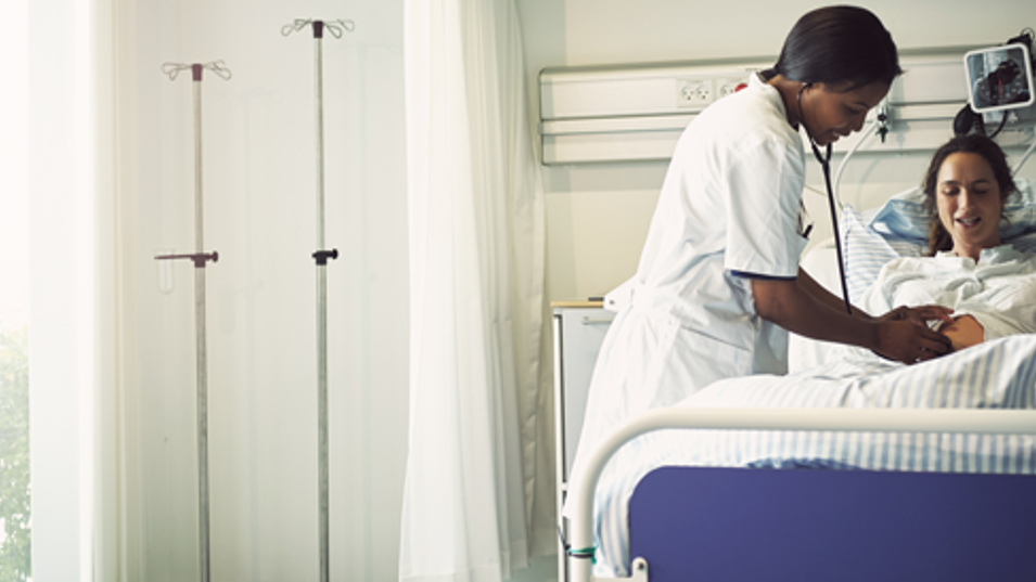 Læge tilser patient i hospitalsseng