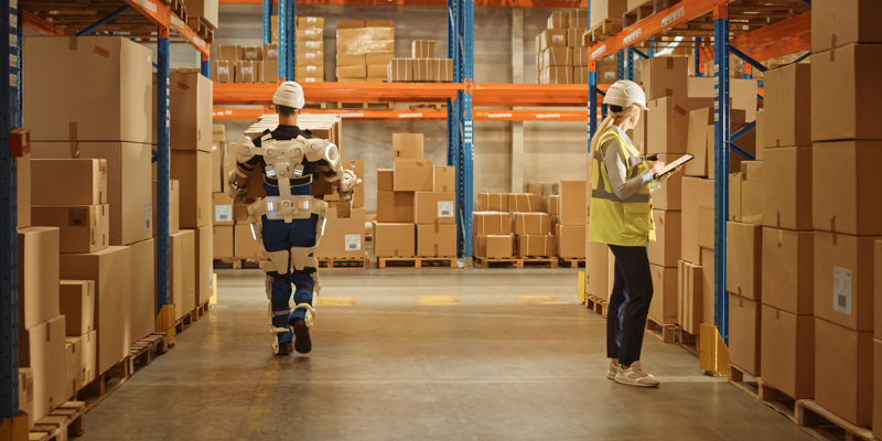 En mand der arbejder i et lager med et exoskelet på, og en kvinde der bruger en ipad