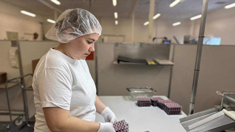 En medarbejder, der er i færd med at pakke piller