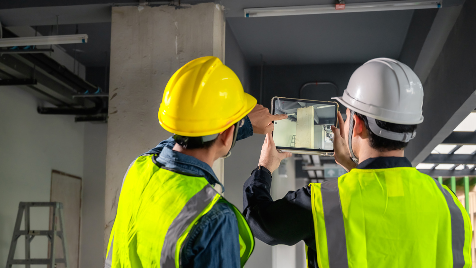 To kolleger der bruger en iPad på byggepladsen