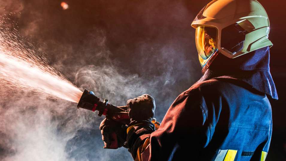 Brandmand i gang med at slukke en brand.