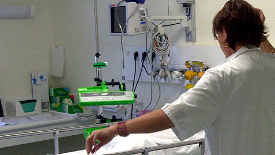 Sygeplejerske på stuegang ved hospitalsseng