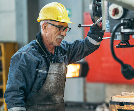 An older employee operating a machine.