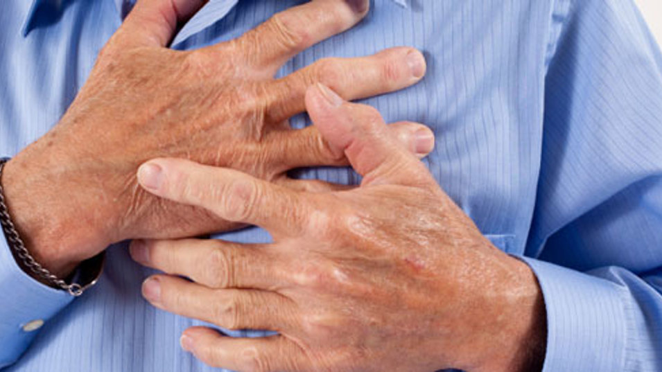 En person i blå skjorte som holder sig til brystet