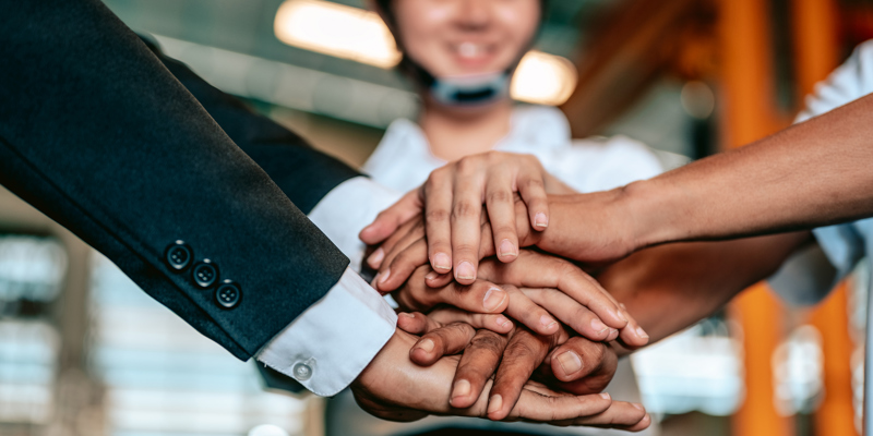 En masse kolleger der har lagt deres hænder oven på hinanden.