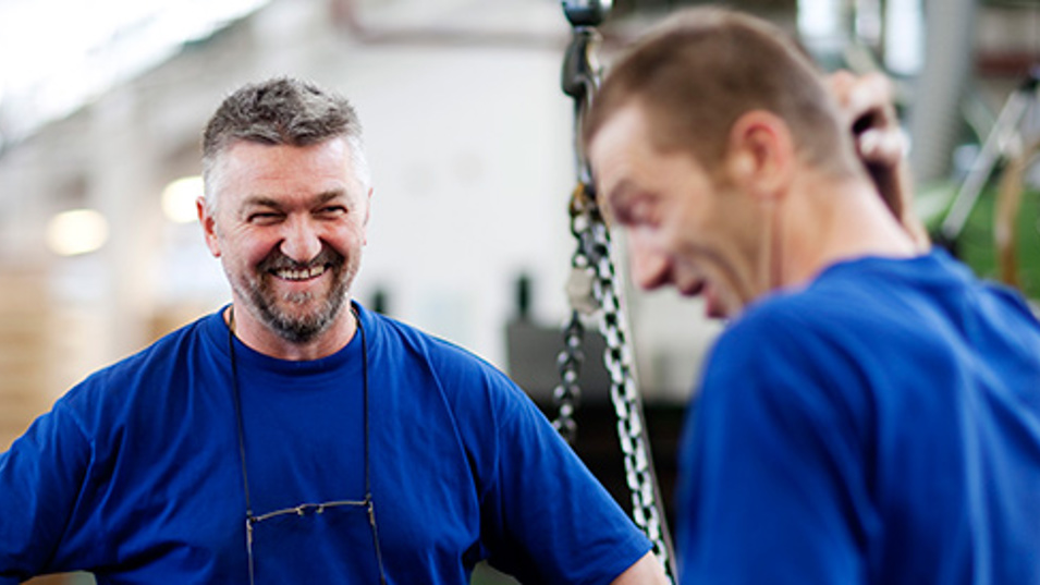 To kolleger der smiler på arbejde