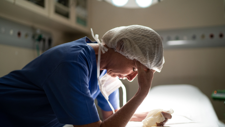 Læge der tager sig til hovedet