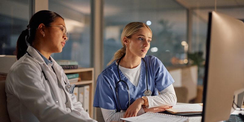 To medarbejdere på et hospital udfører computerarbejde på en nattevagt.