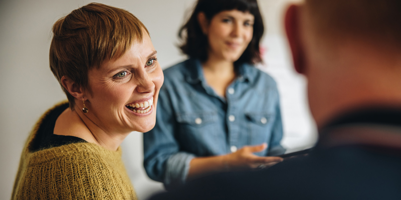 Kvinde smiler til kollega