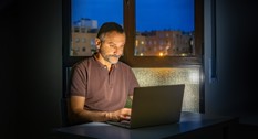 En seniormedarbejder der arbejder hjemmefra om aftenen